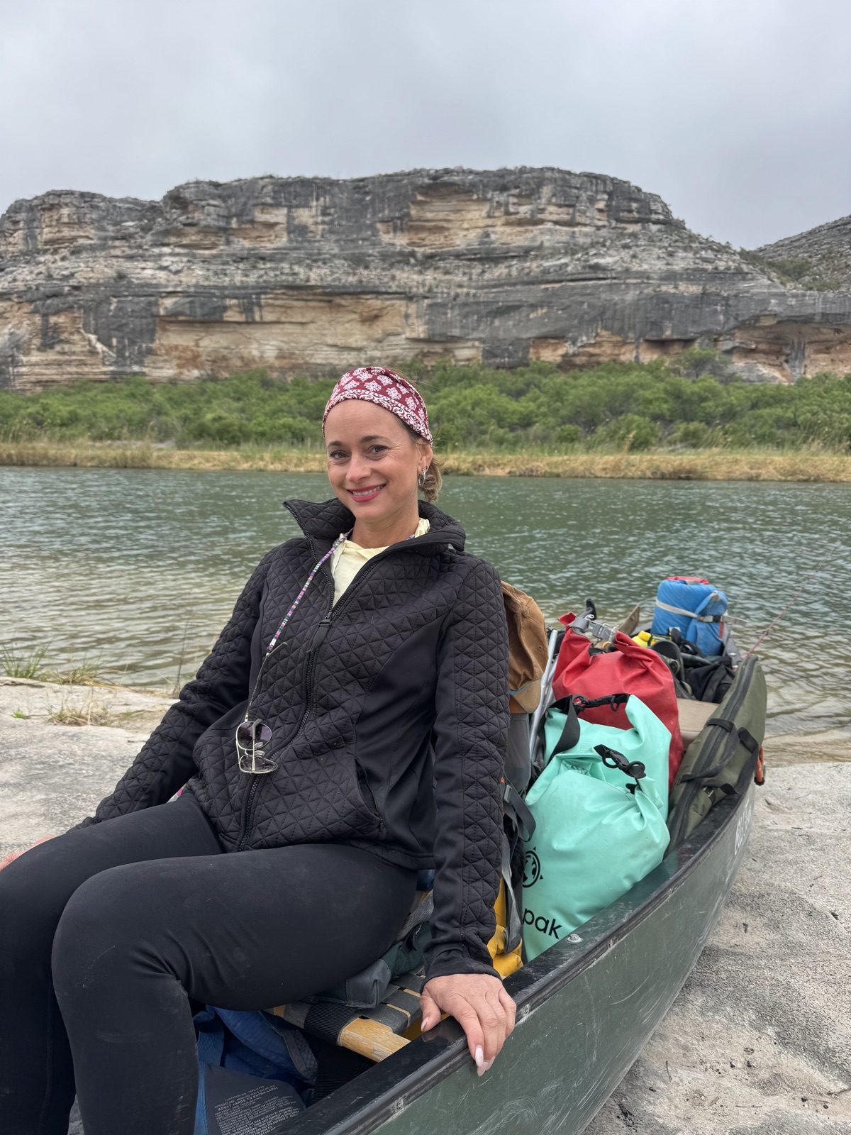 Denise Mazour beside a canoe on the river