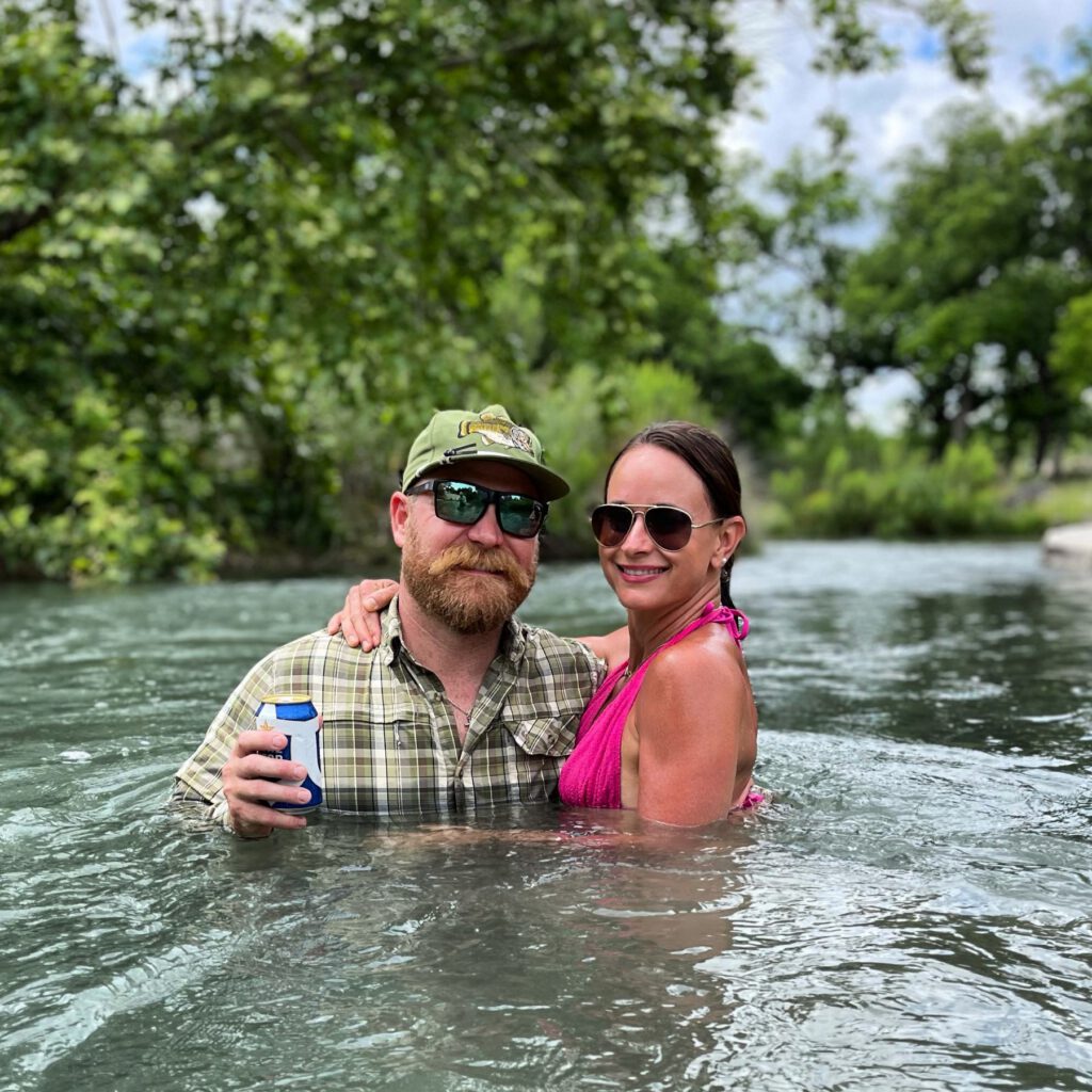 Couple relaxing together in a tree-lined Hill Country river