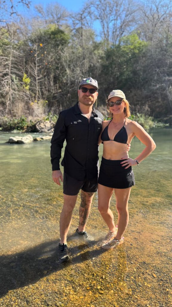 Couple standing together in a shallow Texas Hill Country river
